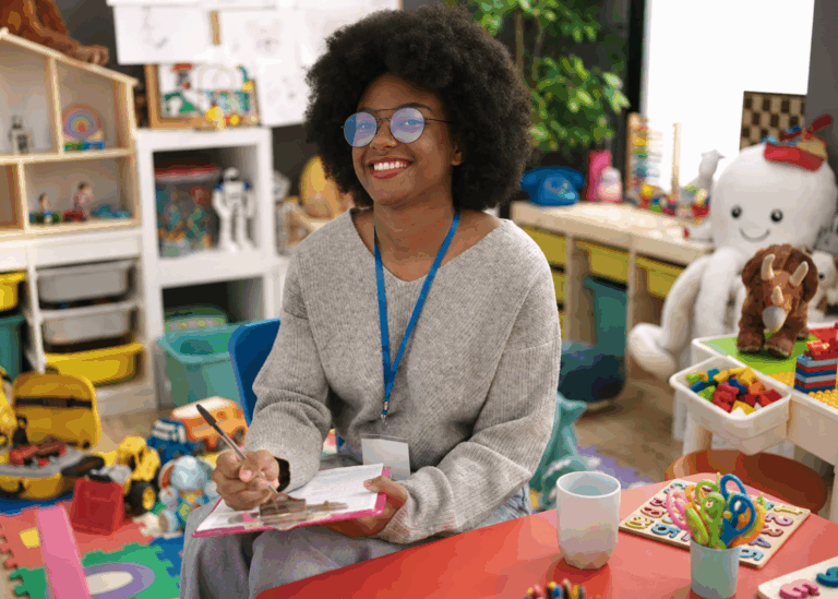 Registered Behavior Technician (RBT) completing session notes while working in a child-centered therapy environment.